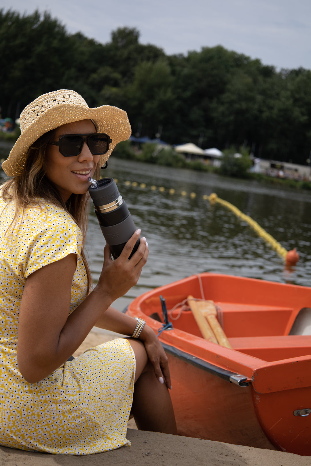 Femme souriant tenant un Matelisto Autocerbante au bord d'un lac