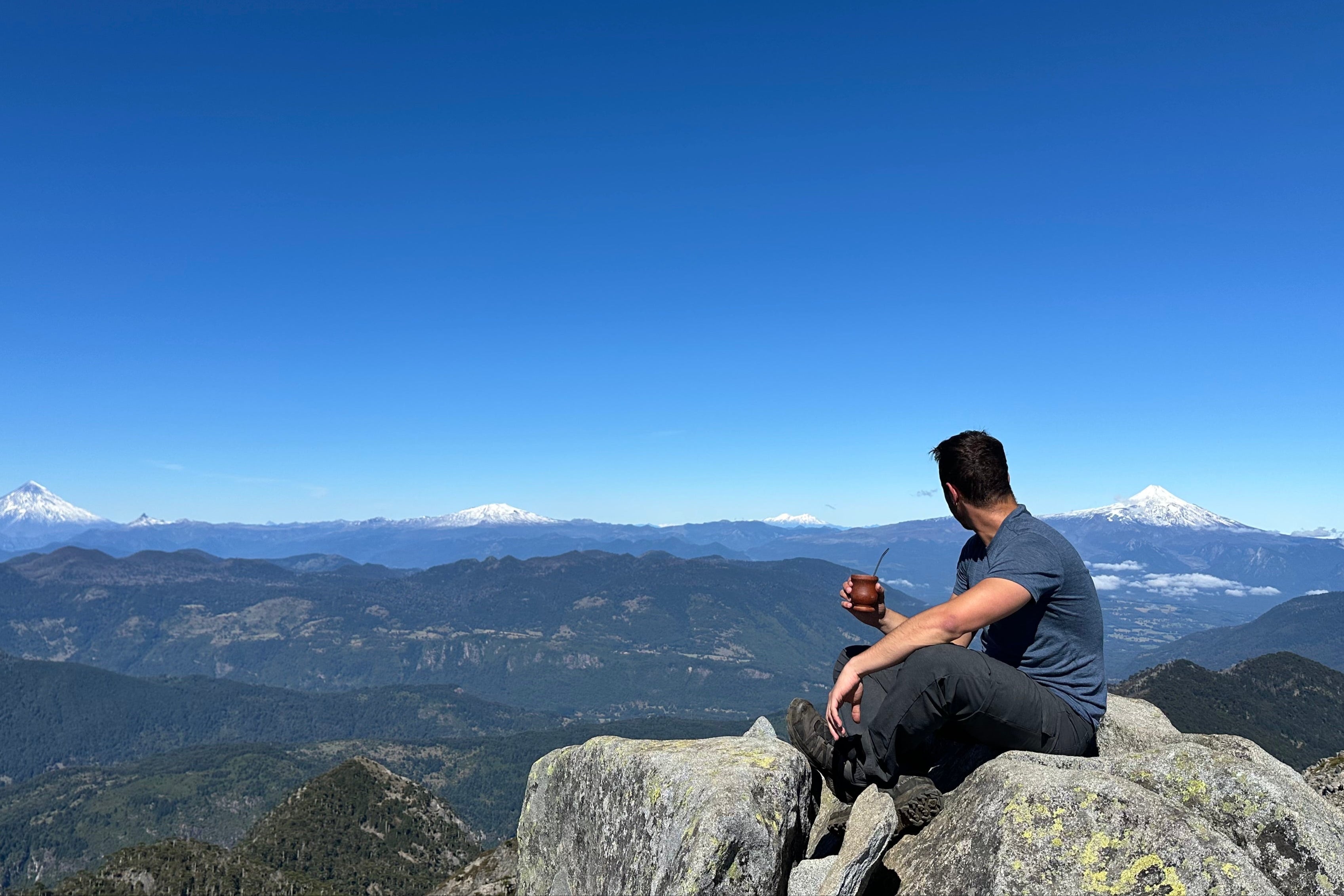 Fondateur en haut d'une montagne, sirotant un maté, observant le paysage