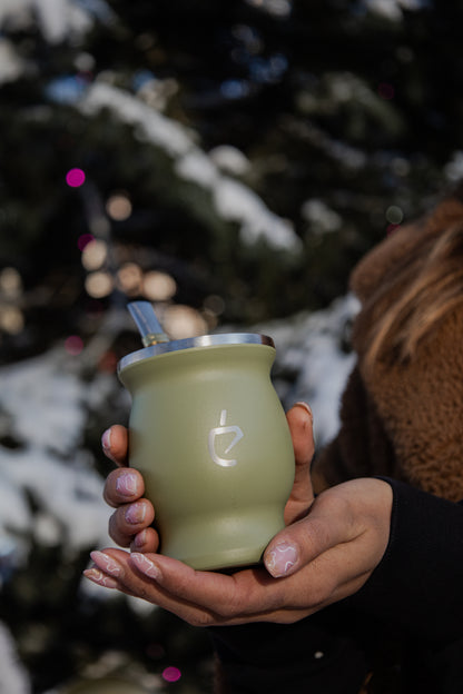 Calebasse verte tenue entre des mains